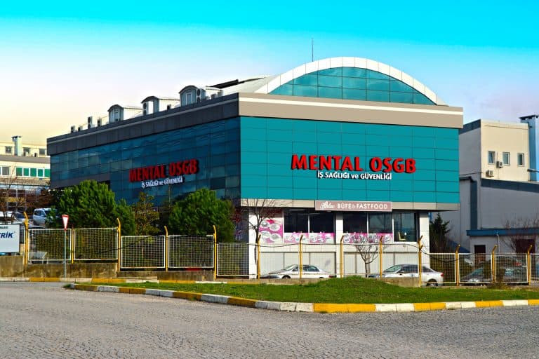 Cephesinde kırmızı harflerle Mental OSGB İş Sağlığı ve Güvenliği yazan iki katlı turkuaz bina